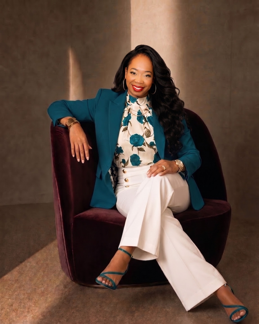 Latoya Belfon, publisher, educator and marketing strategist, seated in a teal suit