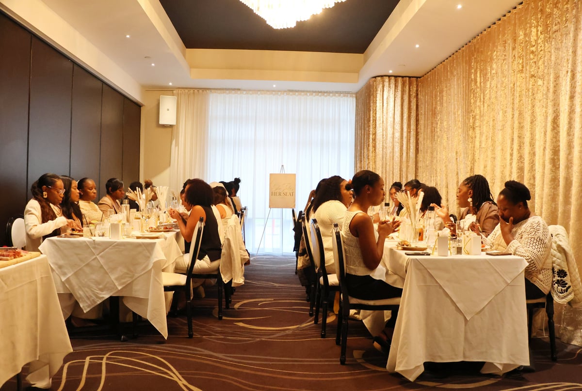 Women seated at elegant dinner tables during the inaugural She Takes Her Seat gathering
